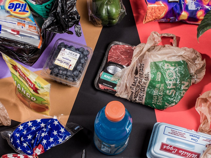 Photo of a variety of single use, disposable plastic from food products arranged on a colorful backdrop and photographed from above.