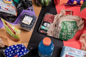 Photo of a variety of single use, disposable plastic from food products arranged on a colorful backdrop and photographed from above.