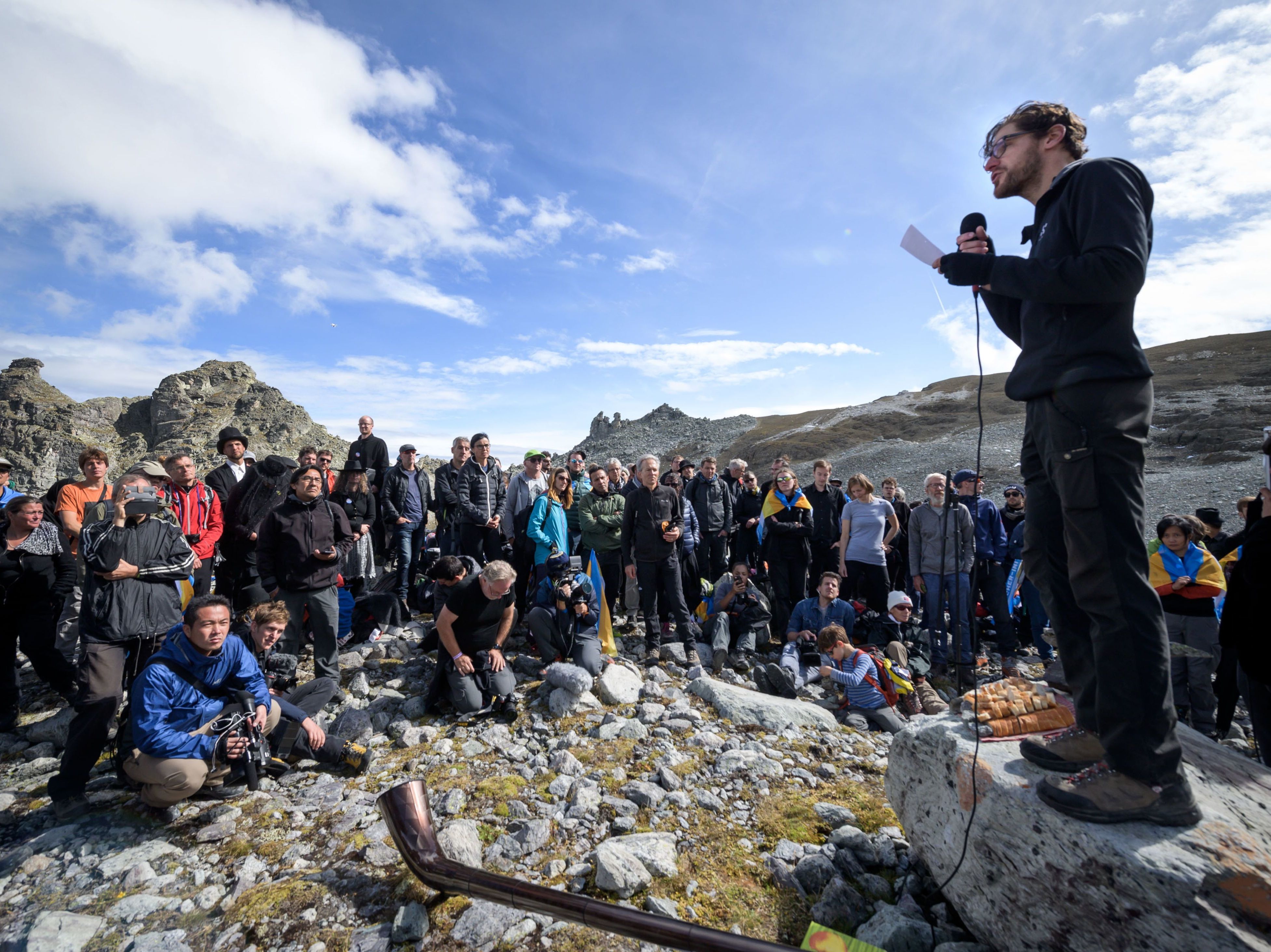 caption: People take part in a ceremony to mark the "death" of the Pizol glacier on Sunday in eastern Switzerland.