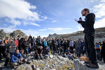 caption: People take part in a ceremony to mark the "death" of the Pizol glacier on Sunday in eastern Switzerland.