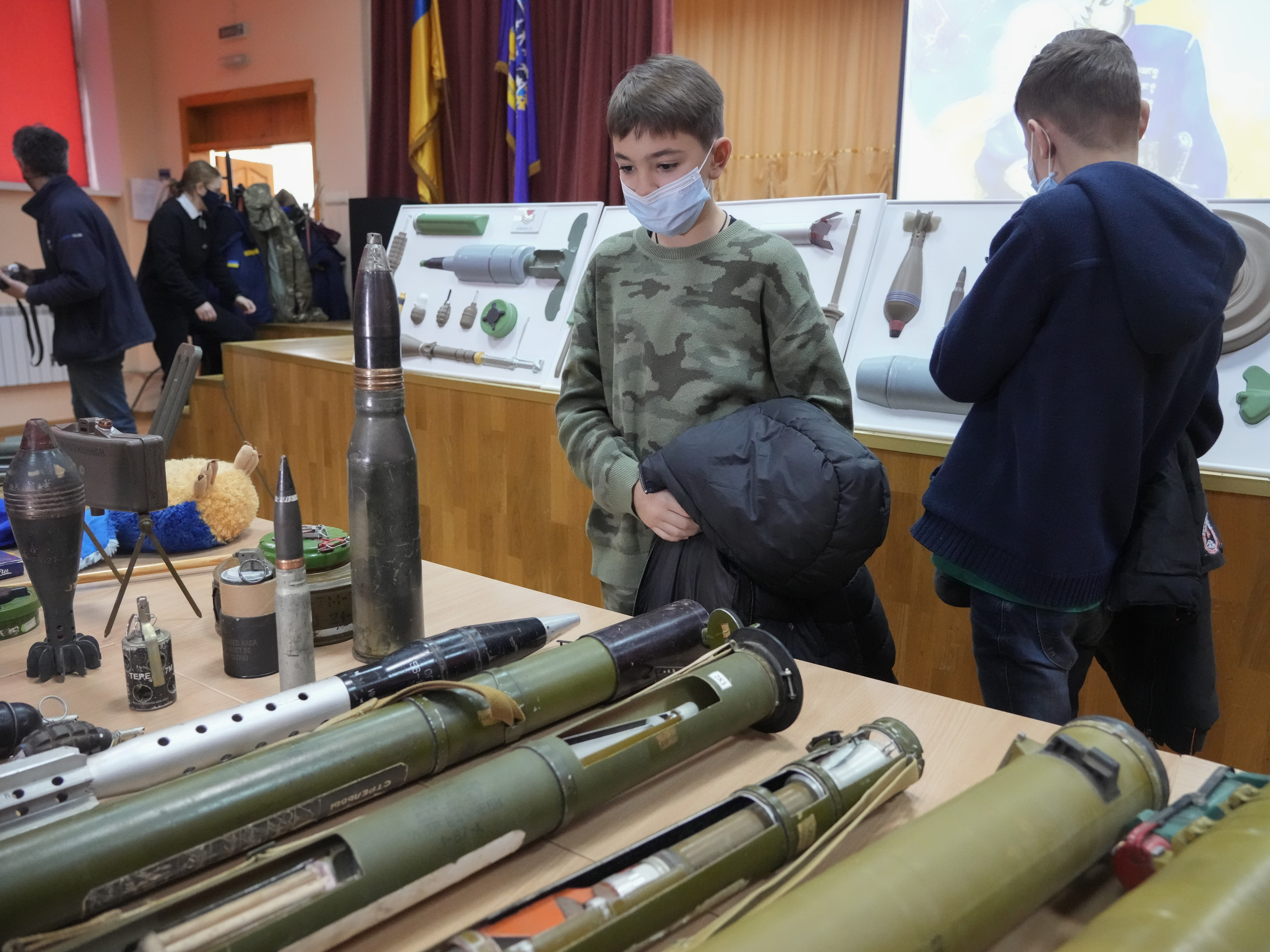 caption: Schoolchildren look at explosives during a police-organized civilian safety lesson in a city school in Kyiv, Ukraine, on Thursday. City authorities have launched training for civilians amid fears about a Russian invasion.