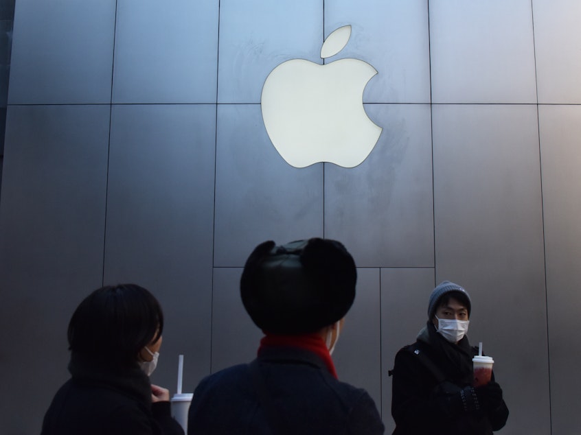 caption: People walk past an Apple store in Beijing in December 2018. Apple CEO cited weaker-than-expected iPhone sales in China as the company lowered its quarterly revenue estimates Wednesday.