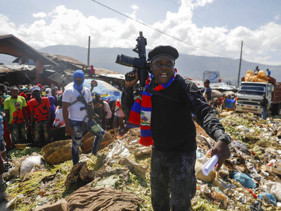 caption: Barbecue, the leader of the "G9 and Family" gang, stands next to garbage Oct. 22 to call attention to the conditions people live in as he leads a march against kidnapping through La Saline neighborhood in Port-au-Prince, Haiti. The group said they were also protesting poverty and for justice in the slaying of President Jovenel Moise.