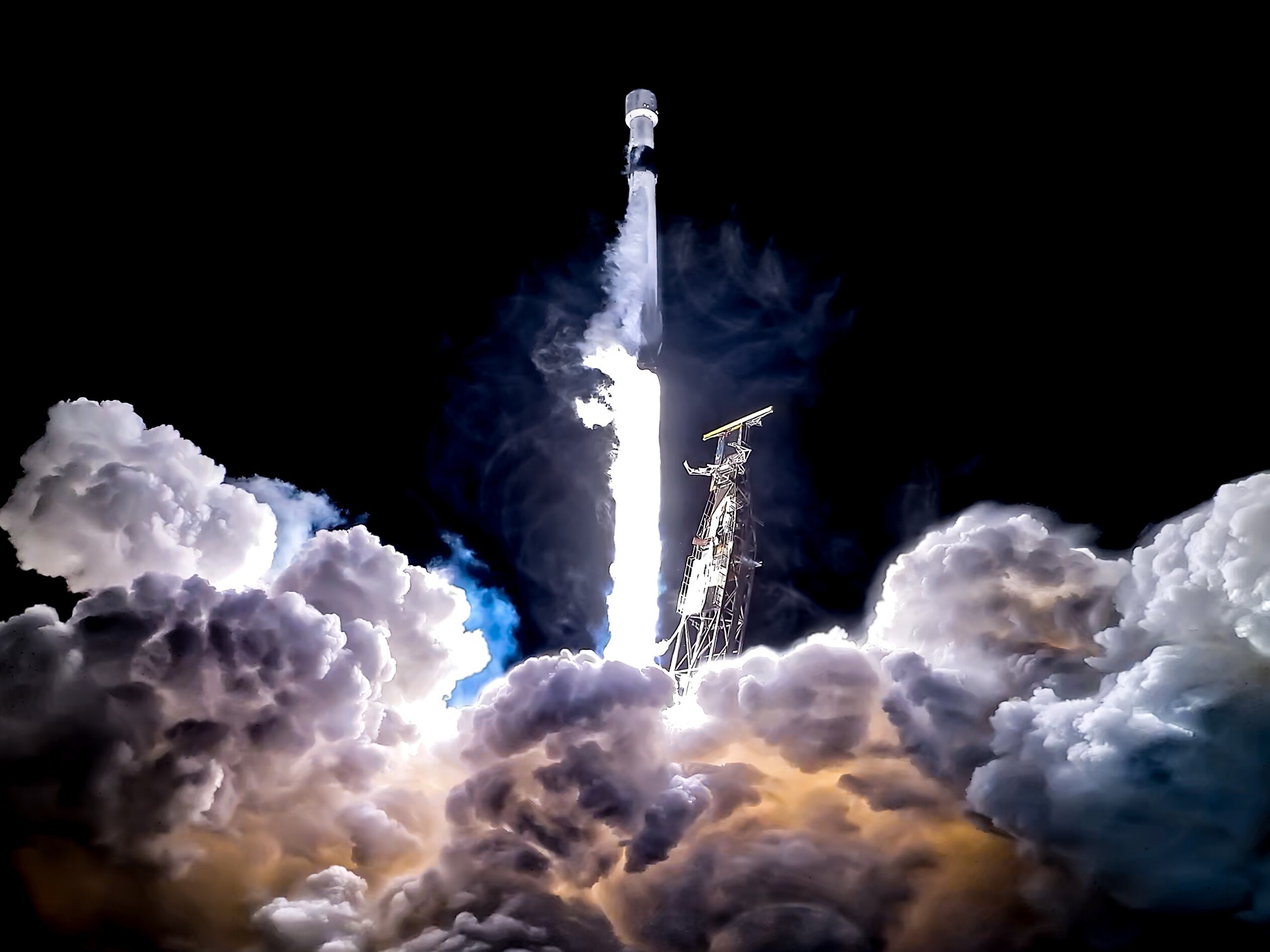 caption: A SpaceX Falcon 9 rocket launched from Vandenberg Space Force Base in March of this year, carrying multiple Starshield satellites into orbit.