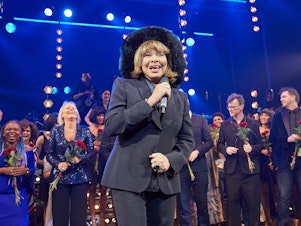 caption: Tina Turner reacts on stage after the German premiere of the musical <em>Tina: The Tina Turner Musical</em> in 2019.