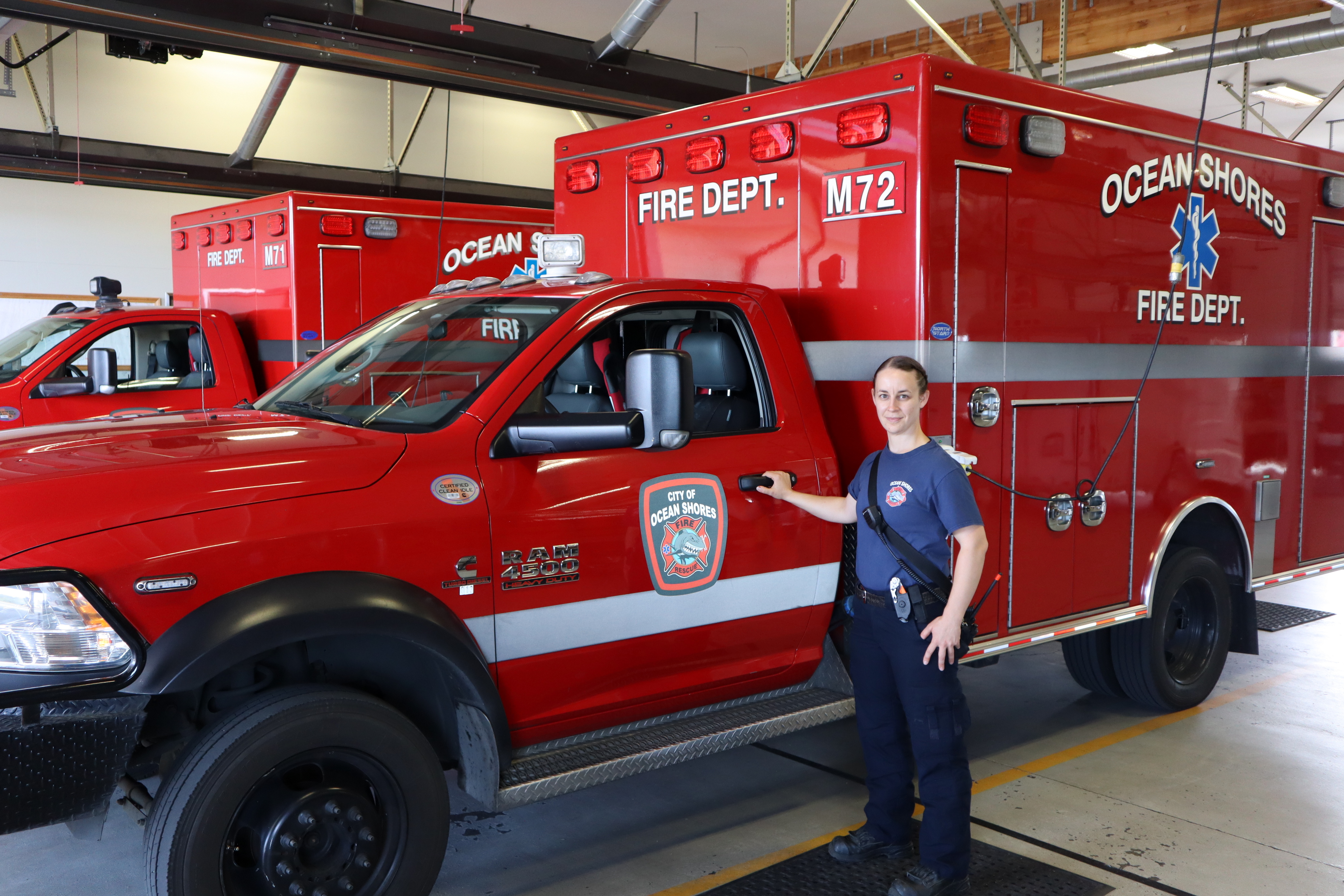 caption: Ocean Shores firefighter/EMT Kara McDermott spends more time than usual behind to wheel of these ambulances as overwhelmed hospitals routinely divert incoming transports.