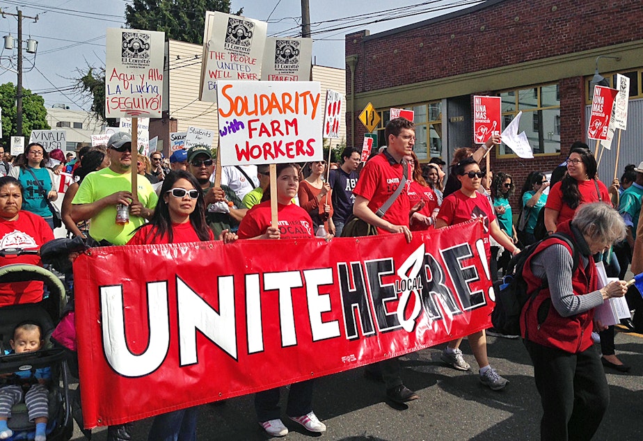 caption: People walk in the May Day labor march in Seattle on Friday, May 1, 2015. 