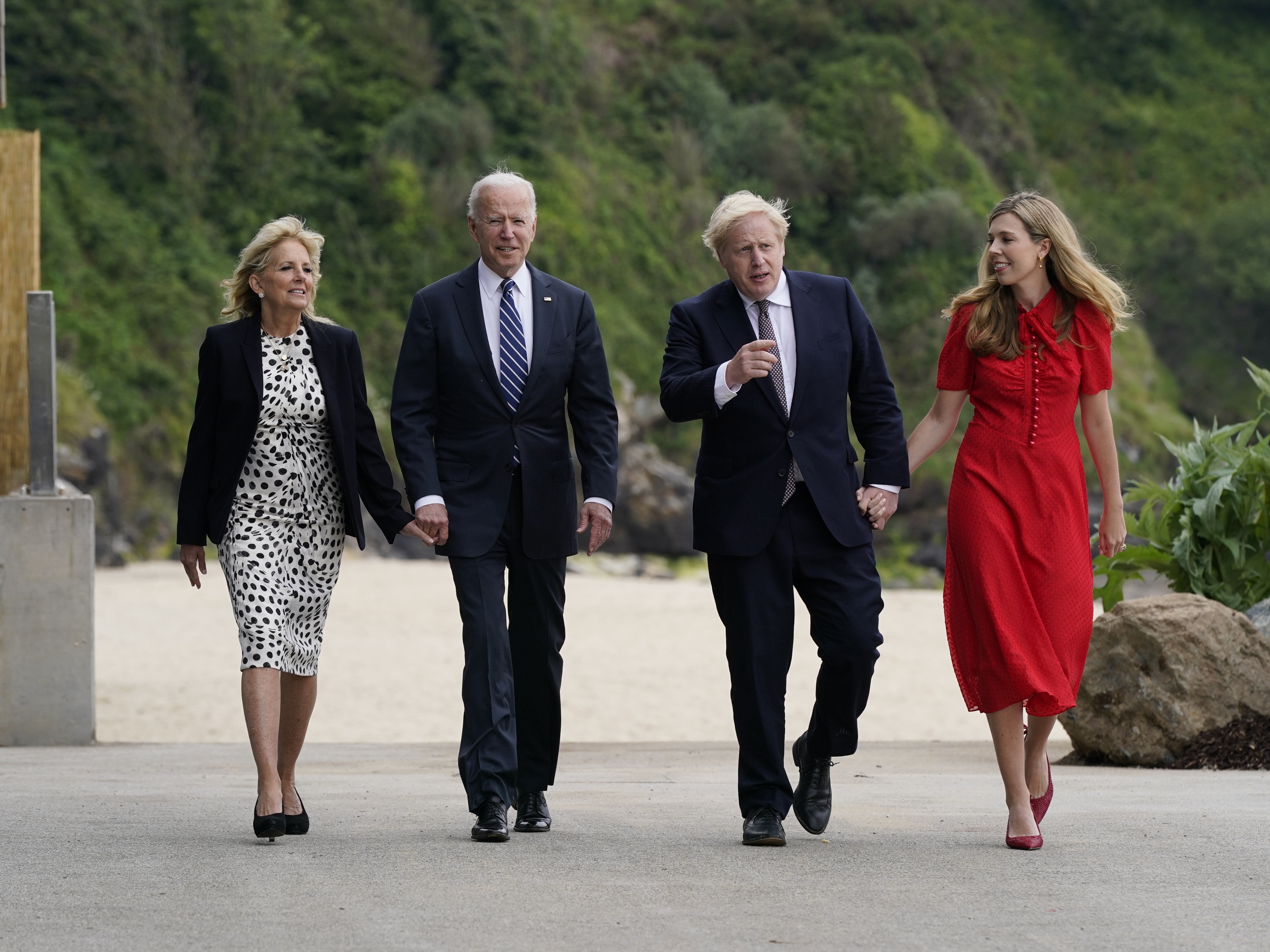 caption: President Biden and first lady Jill Biden walk with British Prime Minister Boris Johnson and his wife Carrie Johnson in  Carbis Bay, England.