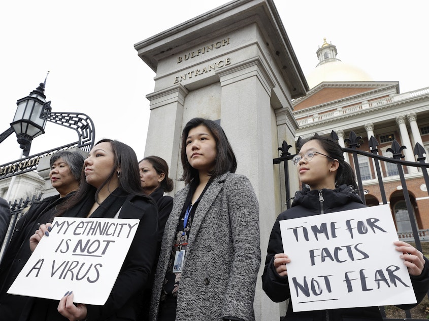 caption: Members of Massachusetts' Asian American Commission protest on March 12 in Boston. Asian American leaders in the state condemned what they say is racism aimed at Asian communities amid the coronavirus pandemic.