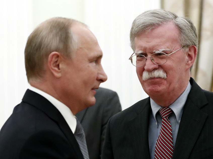 caption: National Security Adviser John Bolton speaks with Russian President Vladimir Putin at the Kremlin on Tuesday. After their meeting, Bolton told reporters the U.S. still intends to withdraw from the Cold War-era Intermediate-Range Nuclear Forces Treaty.