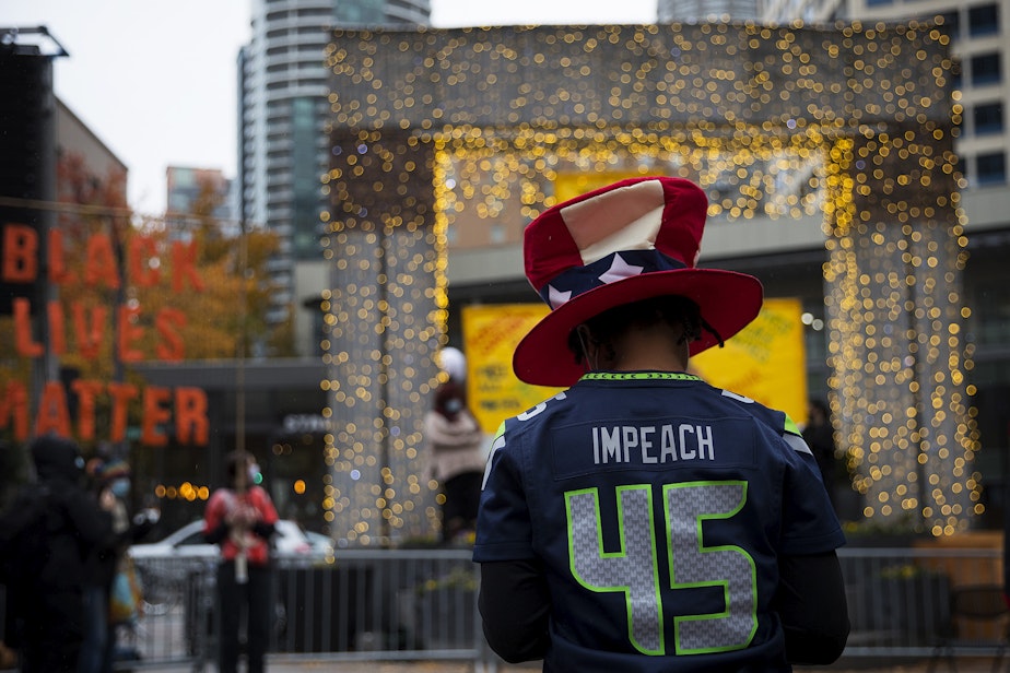 caption: Teri McClain waits for the start of the Our Work Continues: Protect Every Person event, shortly after Joe Biden was officially named the president elect on Saturday, November 7, 2020, at Westlake Park in Seattle.