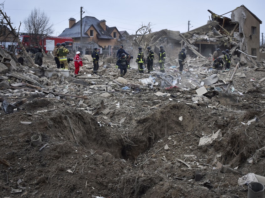 caption: Ukrainian emergency workers clear the debris at the site of Russia's air attack, in Zaporizhzhia, Ukraine, Friday, March 22, 2024.