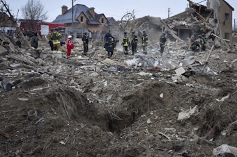 caption: Ukrainian emergency workers clear the debris at the site of Russia's air attack, in Zaporizhzhia, Ukraine, Friday, March 22, 2024.