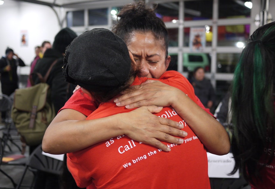 caption: Sylvia Gonzales hugs a friend after President Obama's immigration announcement