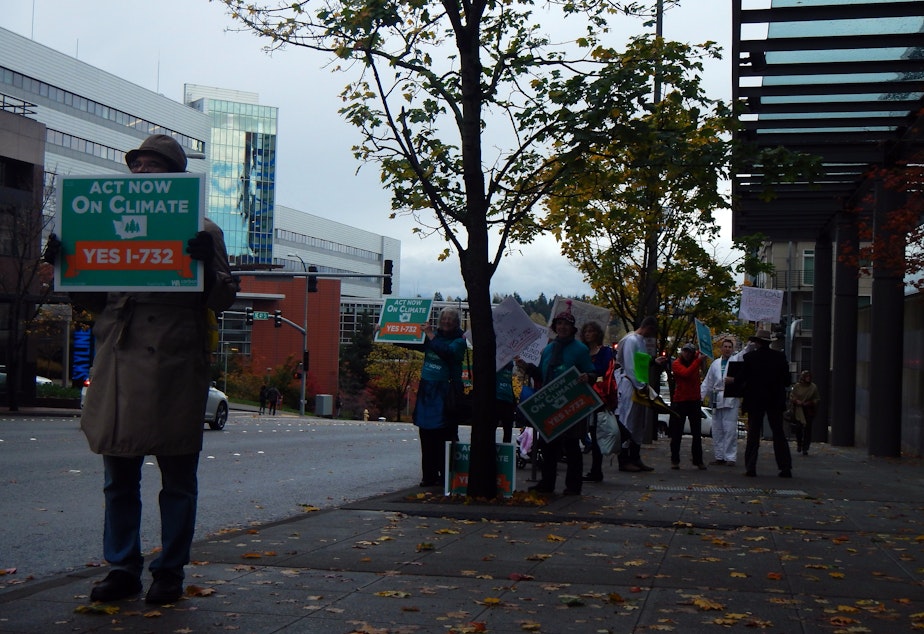 caption: Supporters of a carbon tax demonstrate outside Puget Sound Energy headquarters in Bellevue, Washington.