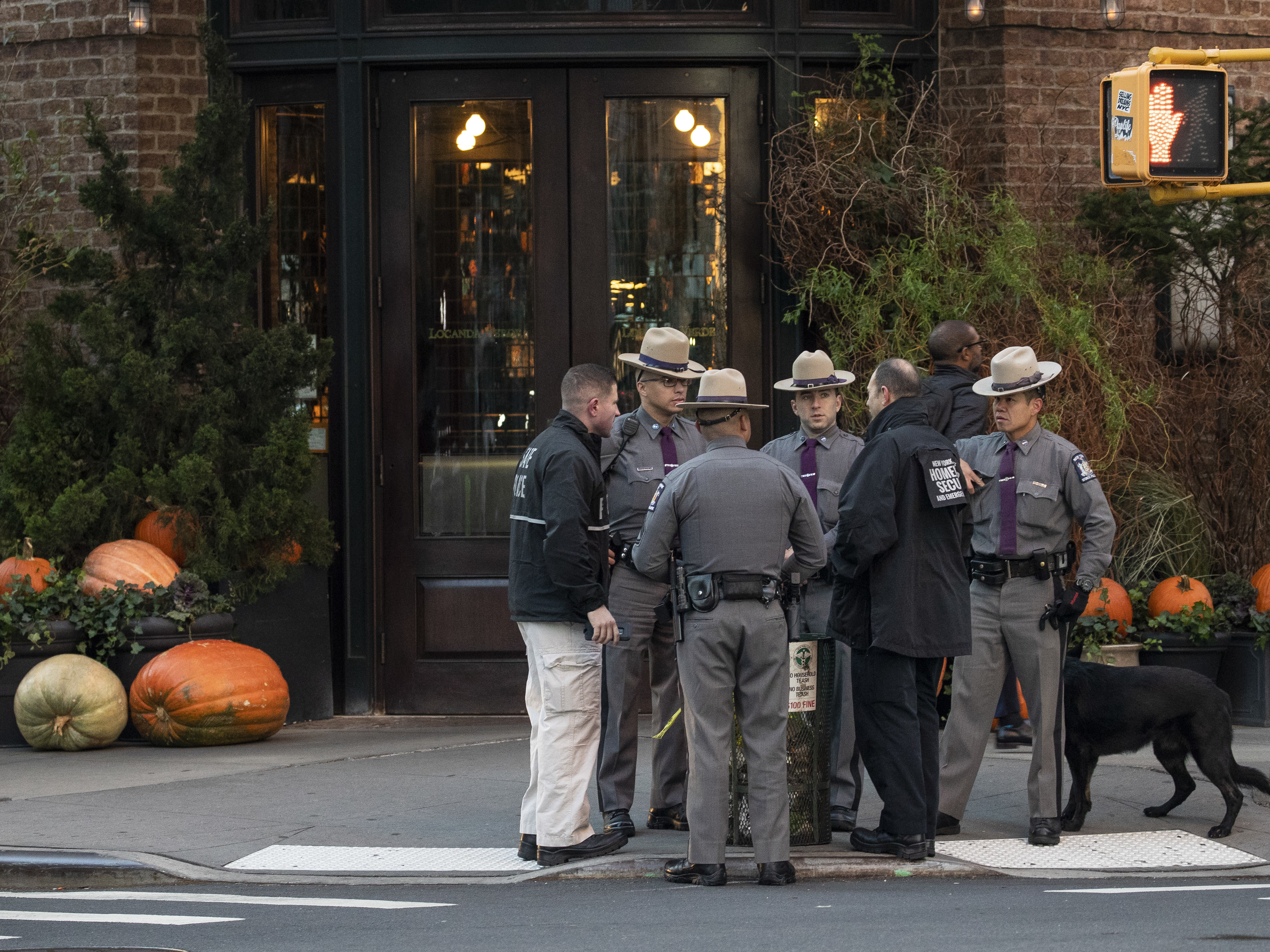 caption: Law enforcement officials gather near Robert De Niro's Tribeca Grill restaurant in New York City after another package bomb was found early Thursday.