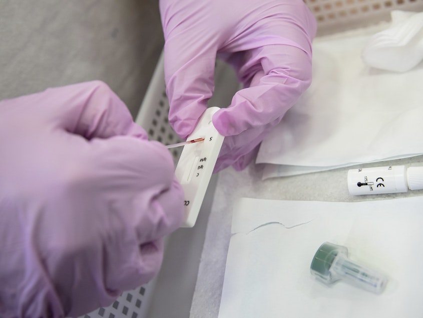 caption: Antibody tests are becoming more available in drugstores, but what do the results <em>really</em> tell you? Above: A Paris pharmacist deposits a blood sample for a COVID-19 antibody test.