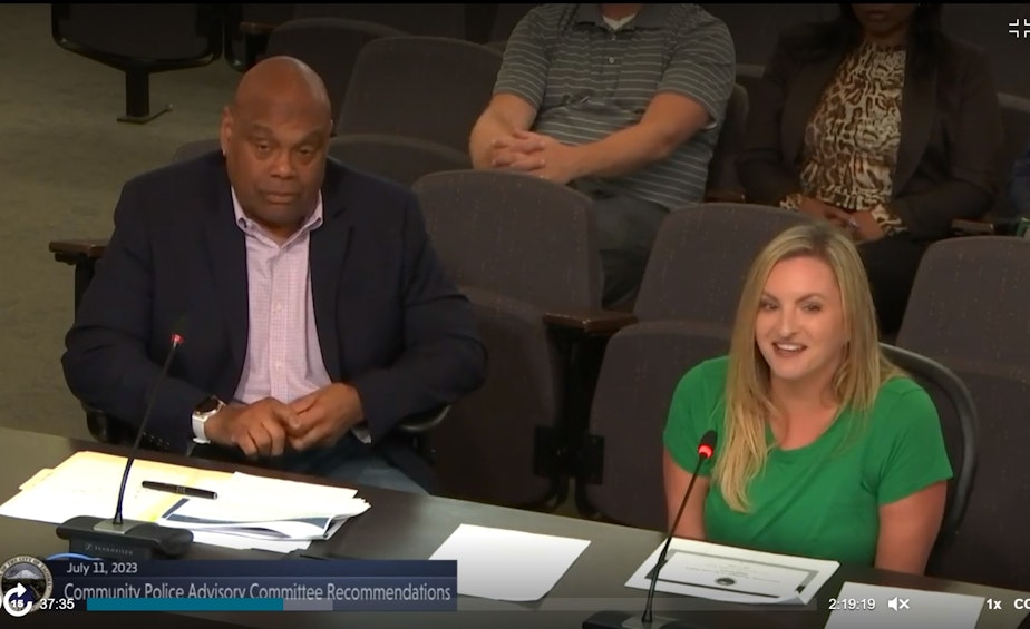 caption: Louis P. Cooper Jr., left, and Shayna Raphael, right, present proposed changes to their Community's Police Advisory Committee in Tacoma on July 11, 2023.