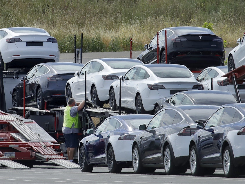 caption: Tesla cars are loaded onto carriers at the automaker's plant in Fremont, Calif., on May 13, 2020. The company is recalling nearly 363,000 vehicles with its "Full Self-Driving" system.