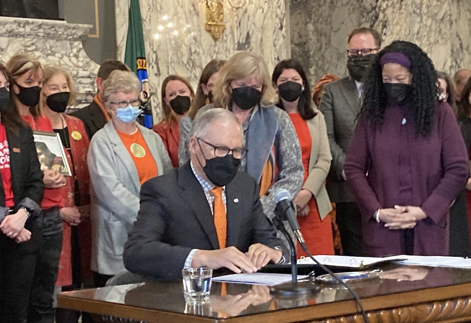 caption:  Gov. Jay Inslee prepares to sign gun-related legislation at a bill signing ceremony in the State Reception Room at the Capitol on Wednesday, March 23, 2022. One of the bills bans the manufacture and sale of gun magazines that hold more than 10 rounds of ammunition. 
