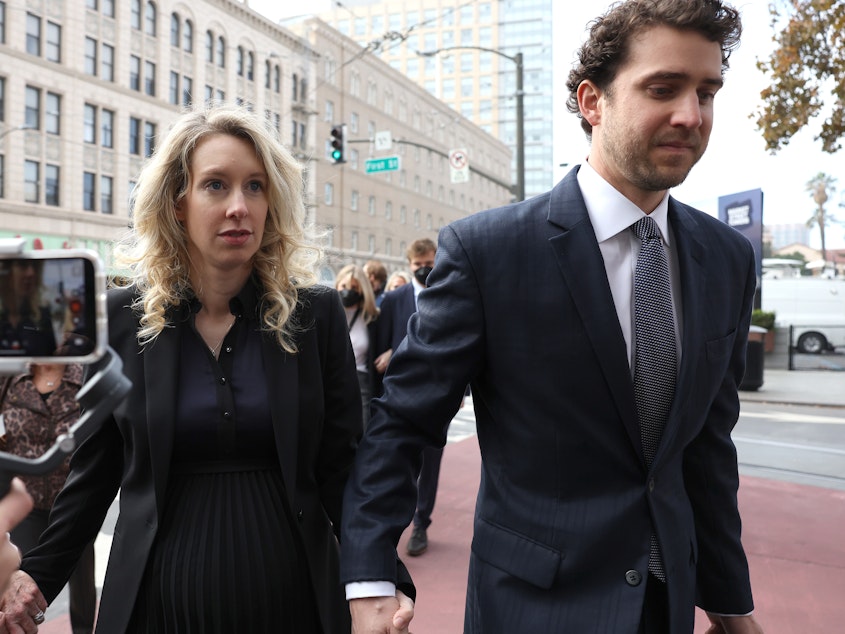 caption: Former Theranos CEO Elizabeth Holmes arrives for her sentencing at federal court with her partner Billy Evans in San Jose, California. Holmes was convicted of four counts of fraud for allegedly engaging in a multimillion-dollar scheme to defraud investors.