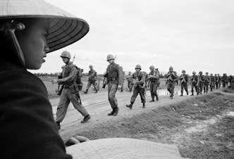 caption: Marines marching in Danang. March 15, 1965.