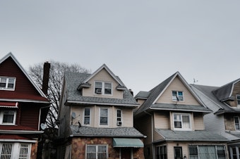 caption: Homes line the street of a Brooklyn neighborhood in March in New York City. Zillow announced it will stop buying and reselling homes, citing the volatility of the housing market.
