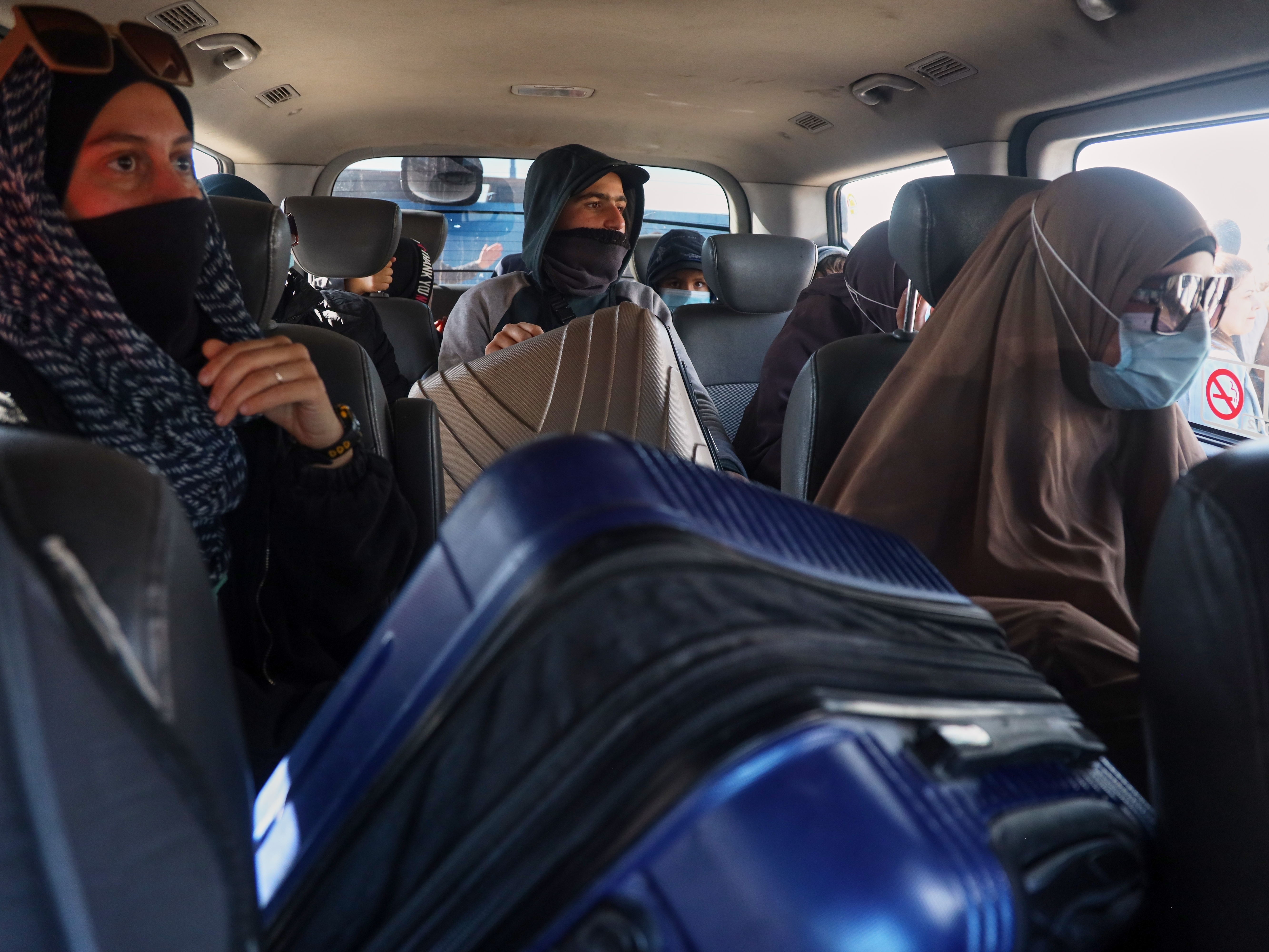 caption: Family members of suspected Islamic State militants who are Australian nationals sit in a van heading to the airport in Damascus during the first repatriation operation of the year, at Roj Camp in eastern Syria, Monday, Feb. 16, 2026. Thirty-four Australian citizens from 11 families departed the camp.