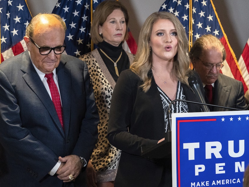caption: Jenna Ellis, right, is seen with other members of former President Donald Trump's legal team, including Rudy Giuliani, left, and Sidney Powell, back, at a Republican National Committee news conference on Nov. 19, 2020.
