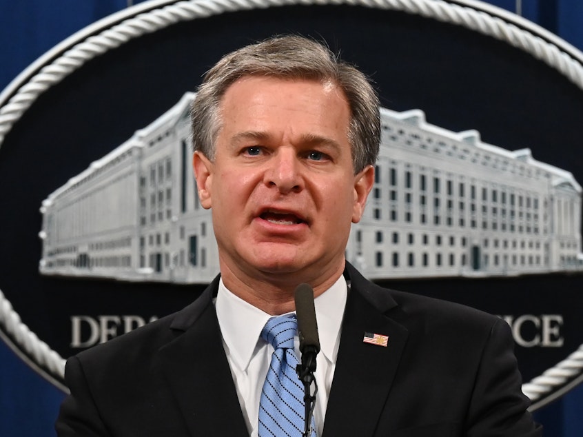 caption: FBI Director Christopher Wray addresses a press conference at the Justice Department in October.