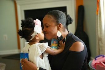 caption: Brittany Smith and her daughter at their home. The family has flourished in Charlotte. Two years ago, Smith and her husband bought a custom-built house and both found new work opportunities.