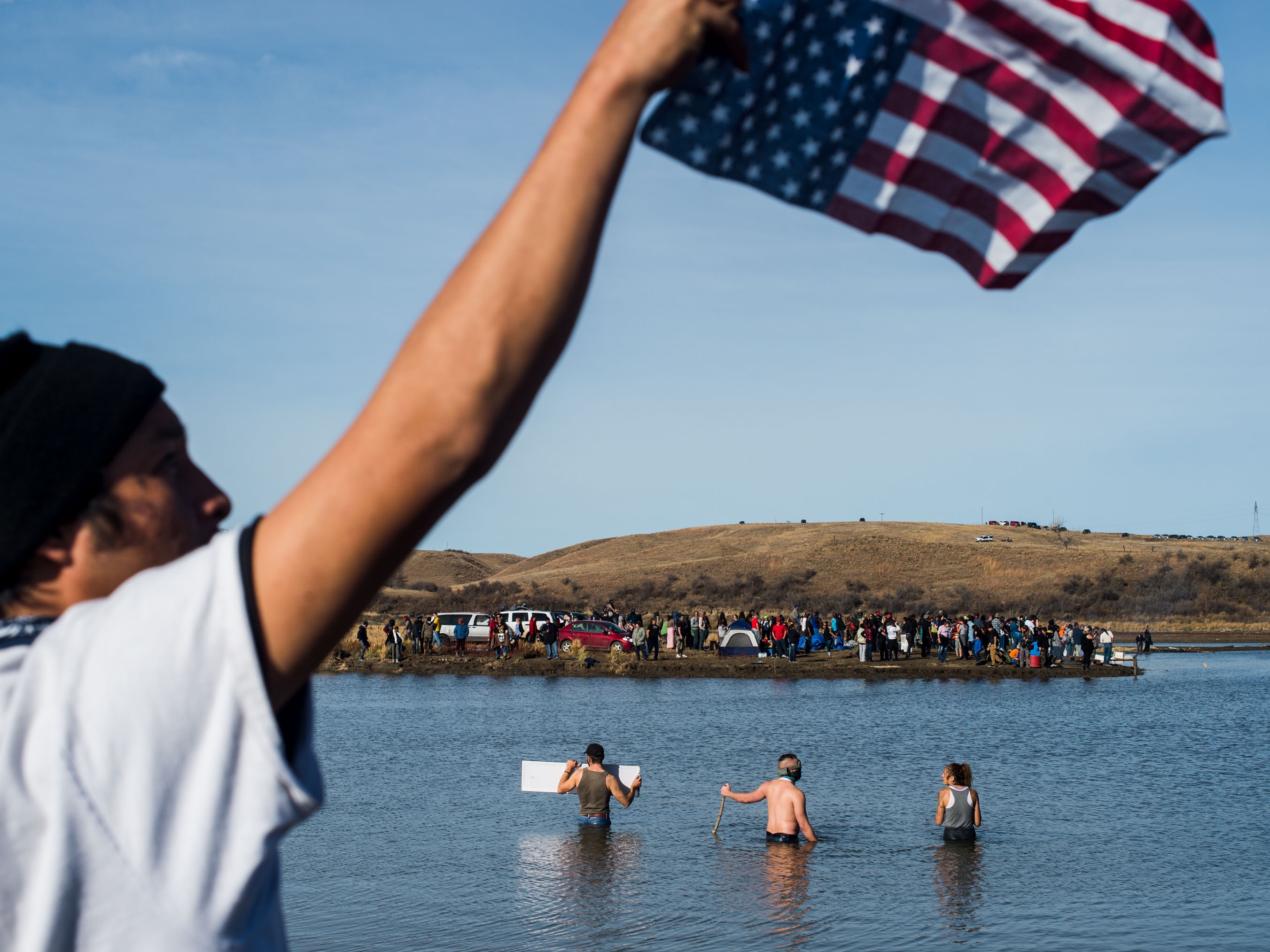 caption: Protesters wade in the Cannon Ball River during a standoff with the police at Turtle Island north of the Standing Rock Reservation in North Dakota, on Nov. 2, 2016.