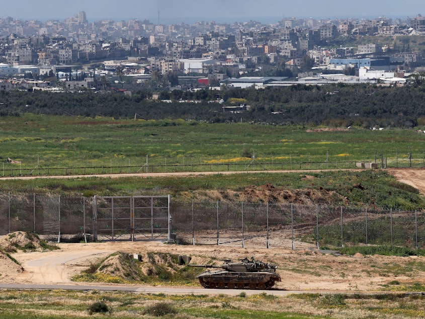 caption: This picture taken from Israel's southern border with the Gaza Strip shows an Israeli army tank moving along the border with the Palestinian territory on March 20.