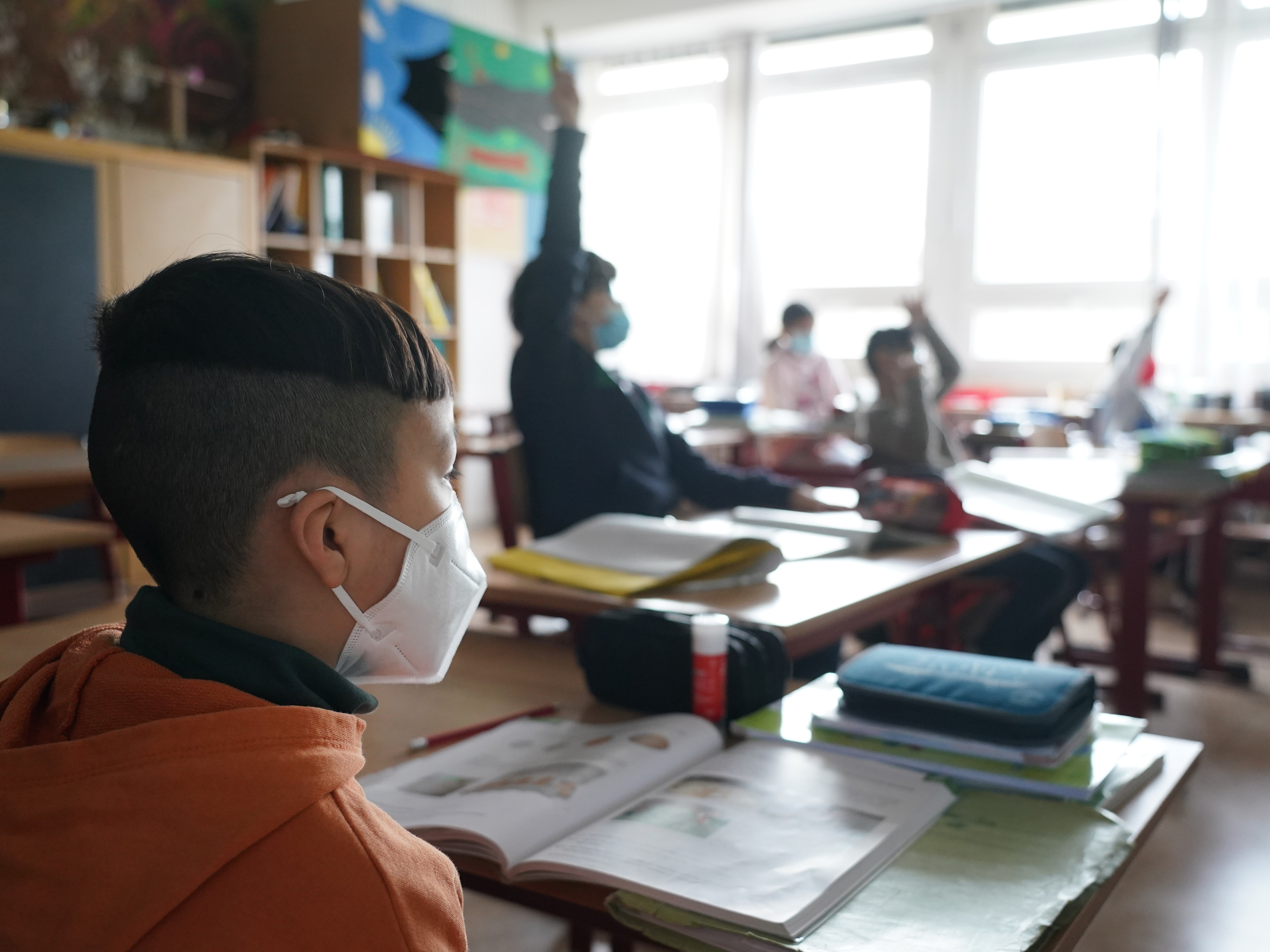 caption: Moderna is testing its COVID-19 vaccine in young children; it's currently authorized for ages 18 and up. Here, third grade children attend school earlier this month in Berlin, as classes were allowed to meet in person at 50% capacity.