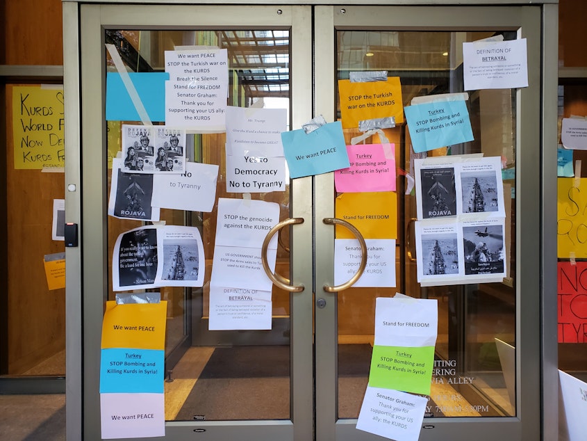 caption: Kurdish protesters taped signs to the front door and windows of the Commercial Attache of Turkey on Sunday, October 13th, 2019.
