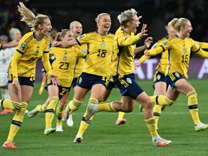 caption: Sweden's forward #08 Lina Hurtig (C) and teammates celebrate their win following a penalty kick shootout over two-time defending champion U.S. at the Women's World Cup. It was the U.S.'s earliest exit from the tournament.