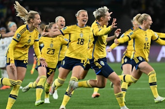 caption: Sweden's forward #08 Lina Hurtig (C) and teammates celebrate their win following a penalty kick shootout over two-time defending champion U.S. at the Women's World Cup. It was the U.S.'s earliest exit from the tournament.