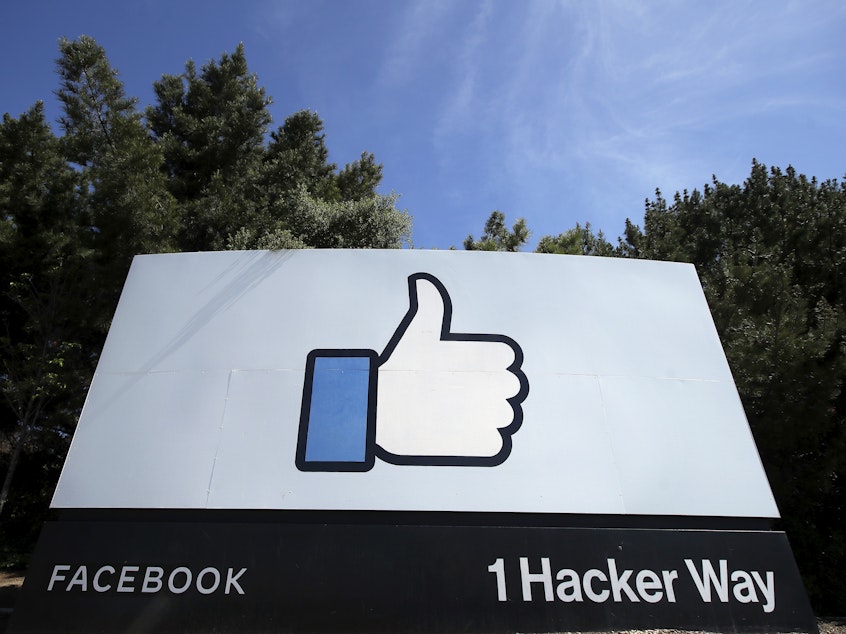 caption: In this April 14, 2020 file photo, the thumbs up "like" logo is shown on a sign at Facebook headquarters in Menlo Park, Calif. Facebook says it plans to hire 10,000 workers in the European Union over the next five years to work on a new computing platform.