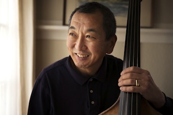 caption: Marcus Tsutakawa, former orchestra director at Seattle's Garfield High School, poses for a portrait with his double bass on Tuesday, November 28, 2017, at his home in Seattle. Marcus is the youngest of George and Ayame Tsutakawa's four children.