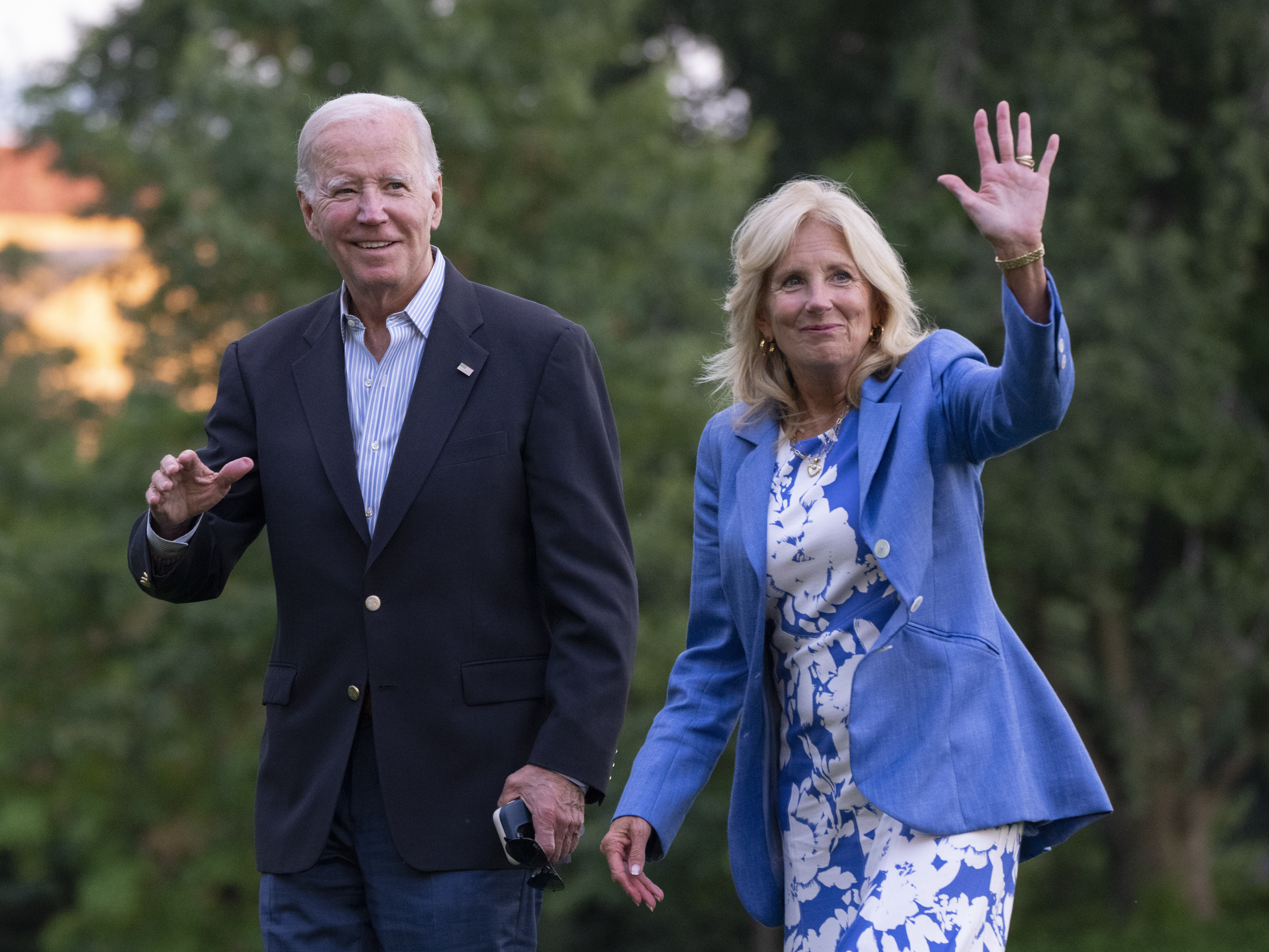 caption: President Joe Biden and first lady Jill Biden wave as they arrive at the White House, Saturday, Aug. 26, 2023, in Washington after a vacation in Lake Tahoe.