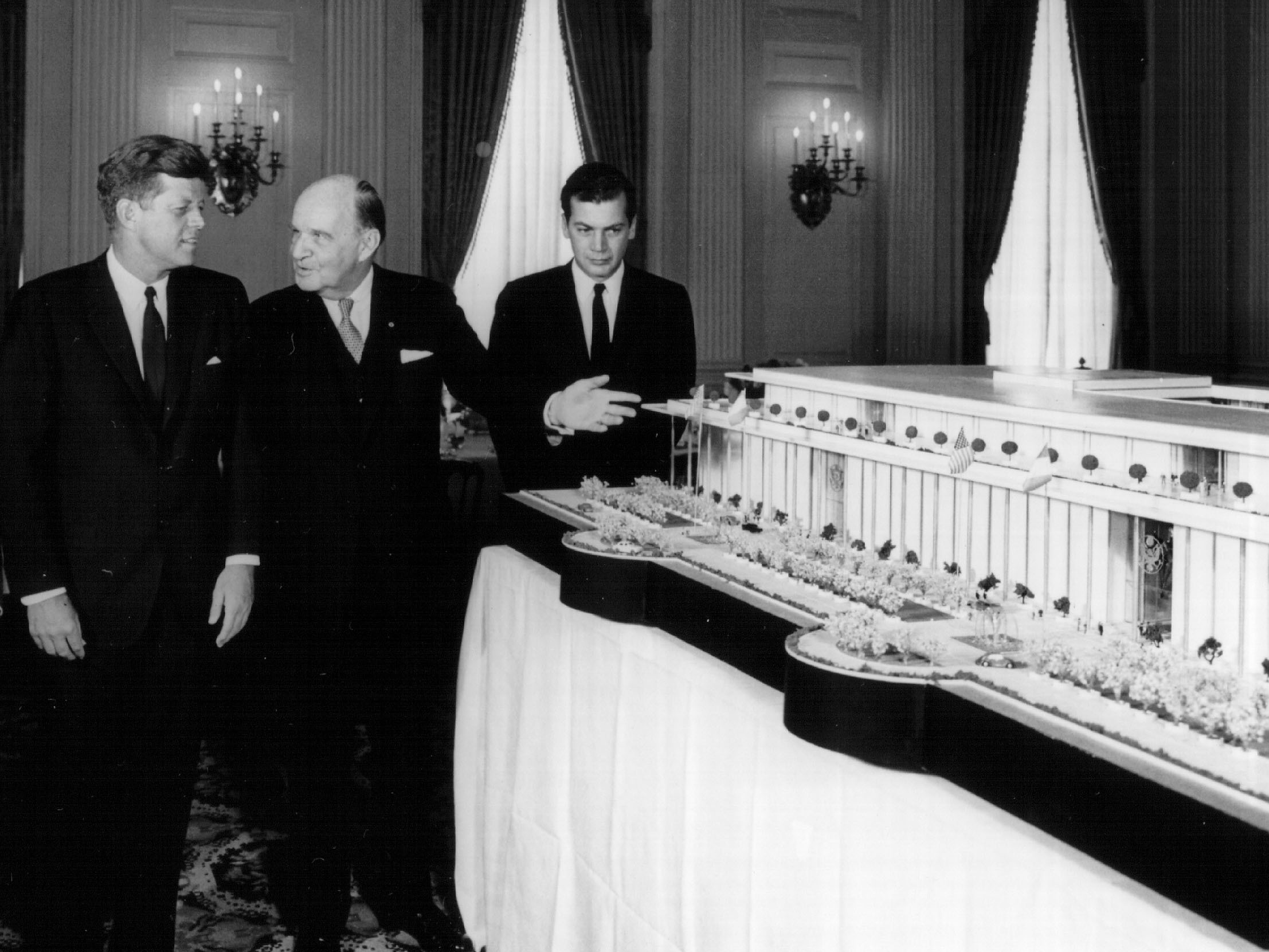 caption: President John F. Kennedy, left, looks at a model of what was later named the Kennedy Center in Washington, DC., in 1963.