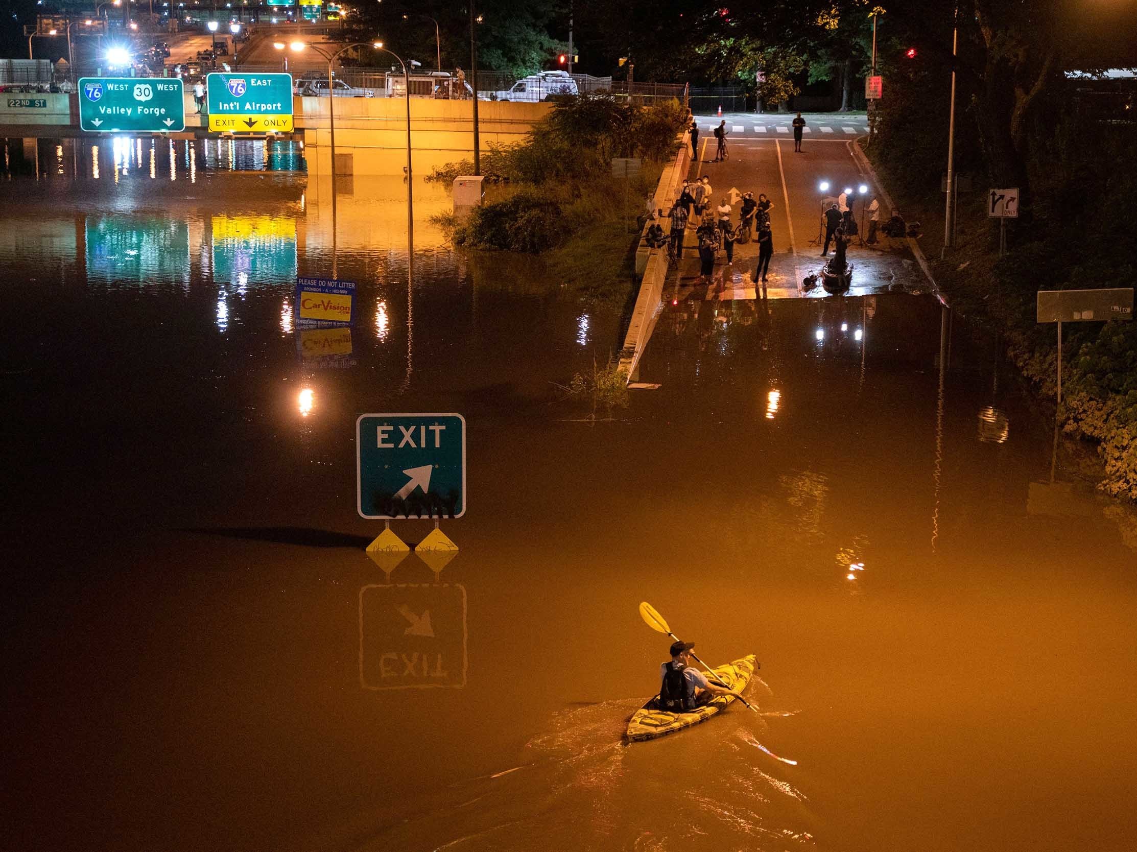 caption: A kayaker paddles down an interstate in Pennsylvania after flooding from Hurricane Ida earlier this year. Several dozen people died, some in cars and basement apartments, during extreme flash flooding.