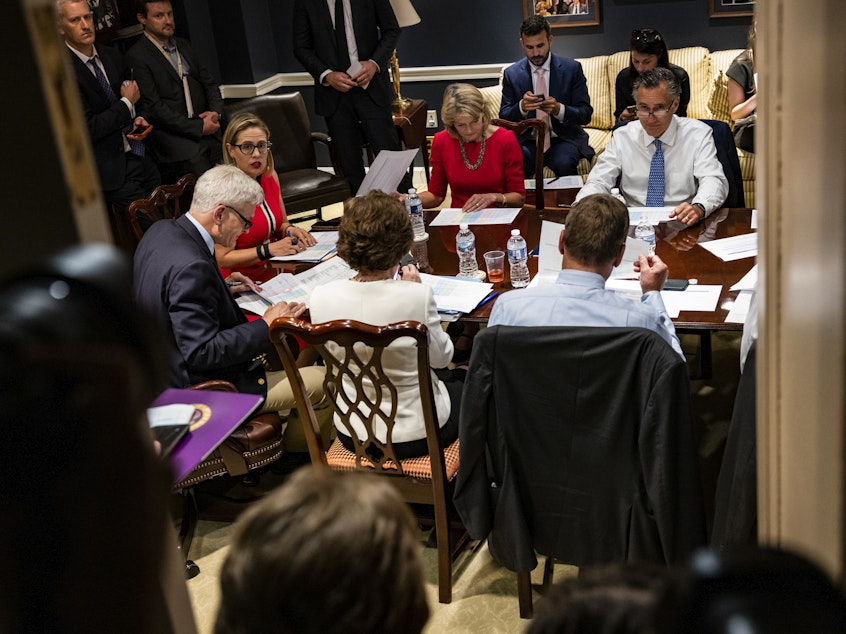 caption: From left: Sens. Bill Cassidy, R-La., Kyrsten Sinema, D-Ariz., Lisa Murkowski, R-Alaska, Mitt Romney, R-Utah, and others hold a bipartisan meeting on infrastructure in the basement of the U.S. Capitol on Tuesday.