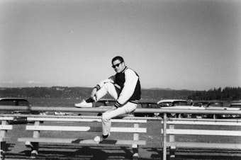 caption: Bruce Lee spent formative years in Seattle. He attended the University of Washington from 1961 to 1964, majoring in philosophy. Behind him is Lake Washington, the subject of many of his poems. 