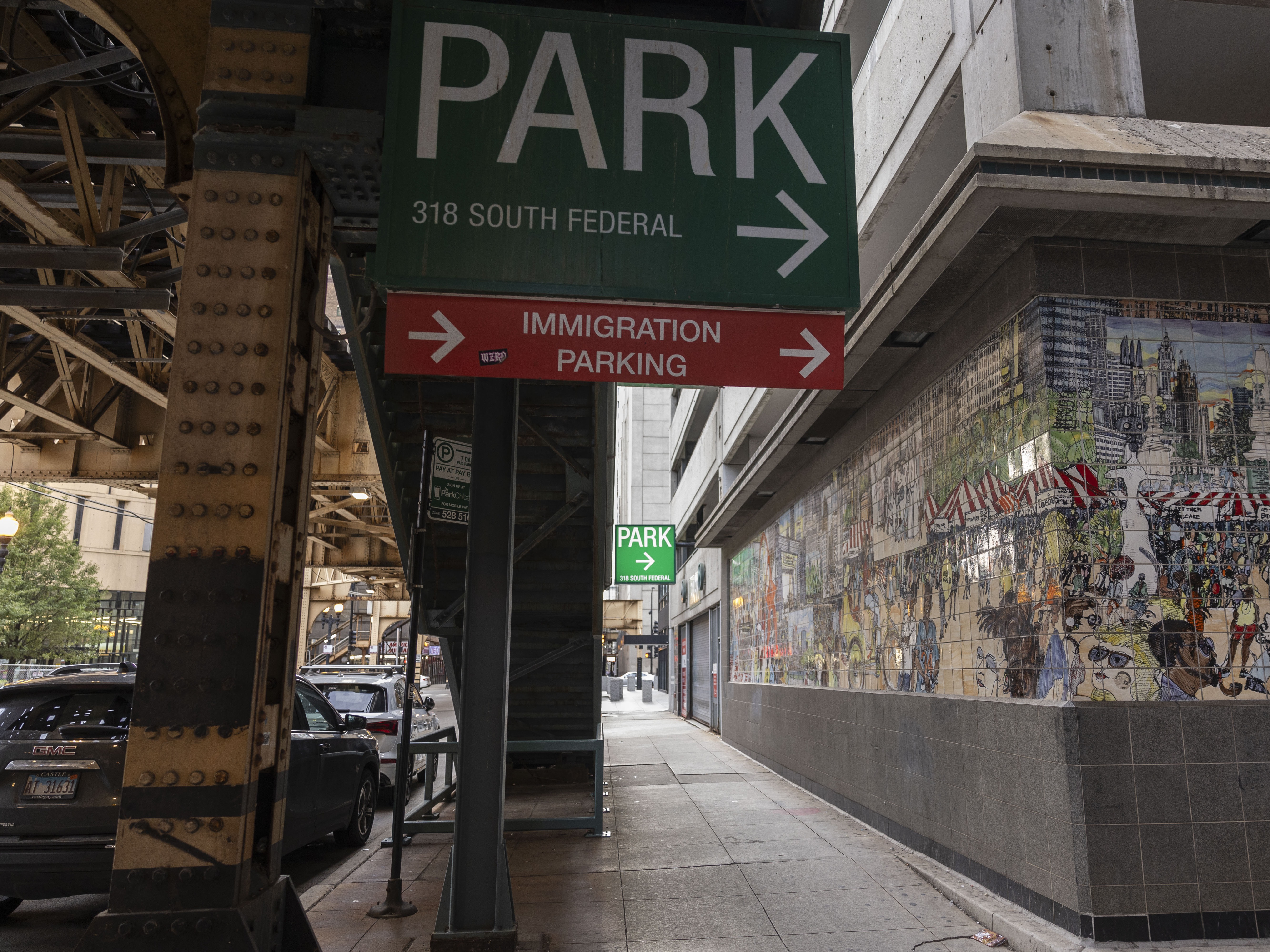 caption: Signs direct traffic to the immigration court parking lot in Chicago, Ill., in August 2024.