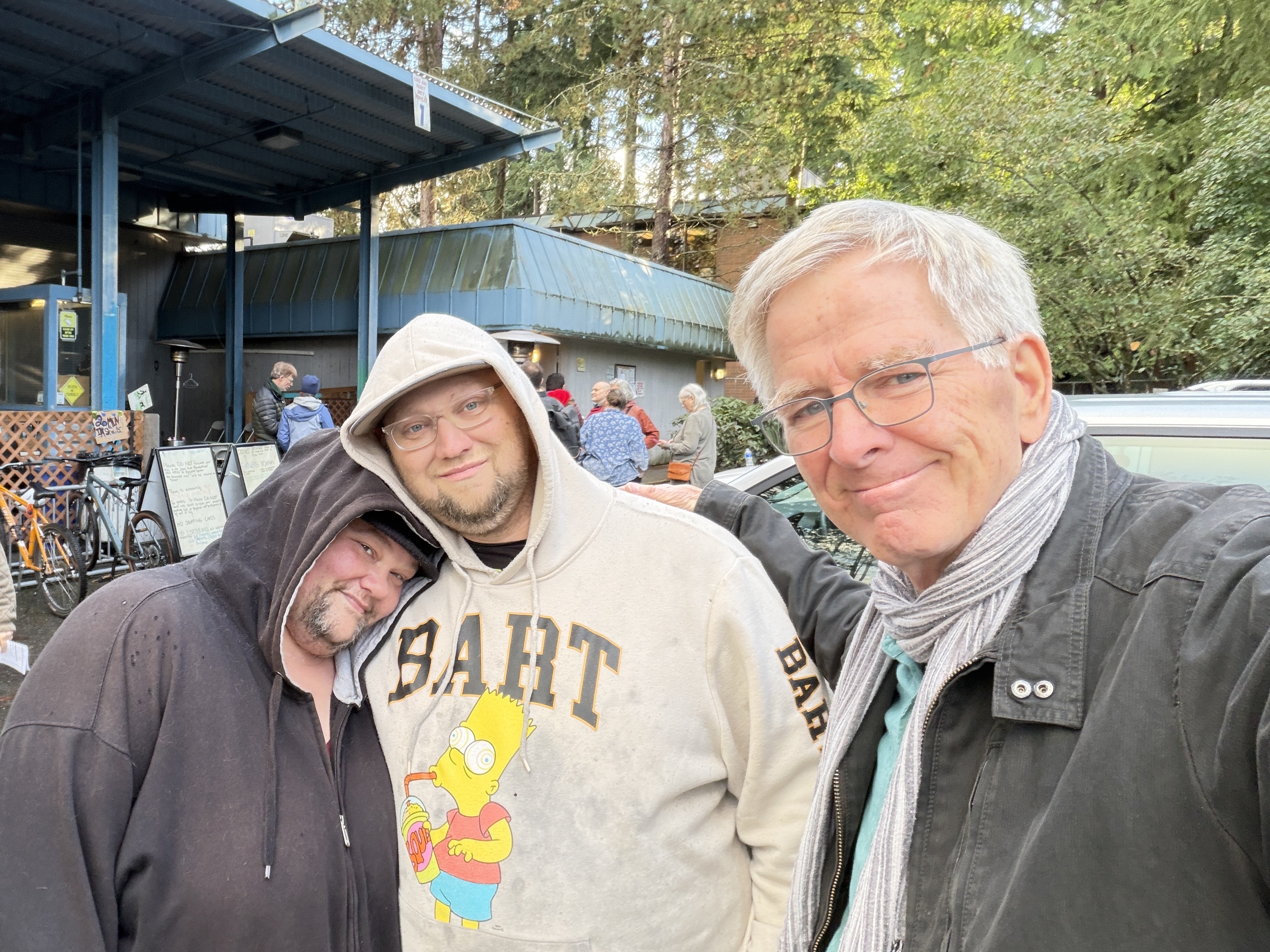 caption: Rick Steves taking a selfie with community members outside the Lynnwood Hygiene Center near Seattle. He says his purchase of the property secures the future of the center, which provides hot meals and hot showers.