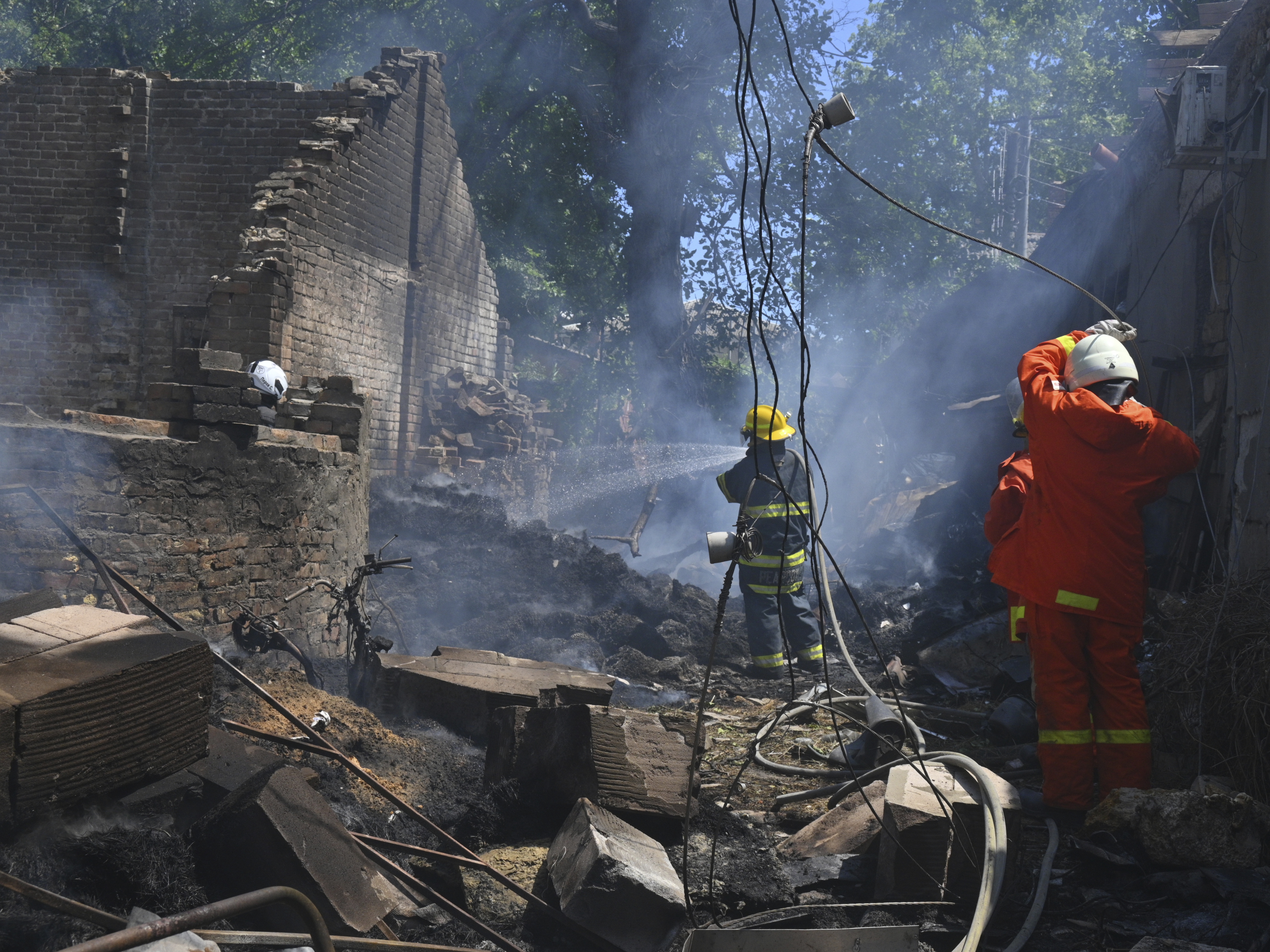 caption: Emergency services personnel work to extinguish a fire following a Russian attack in Odesa, Ukraine, on July 11.