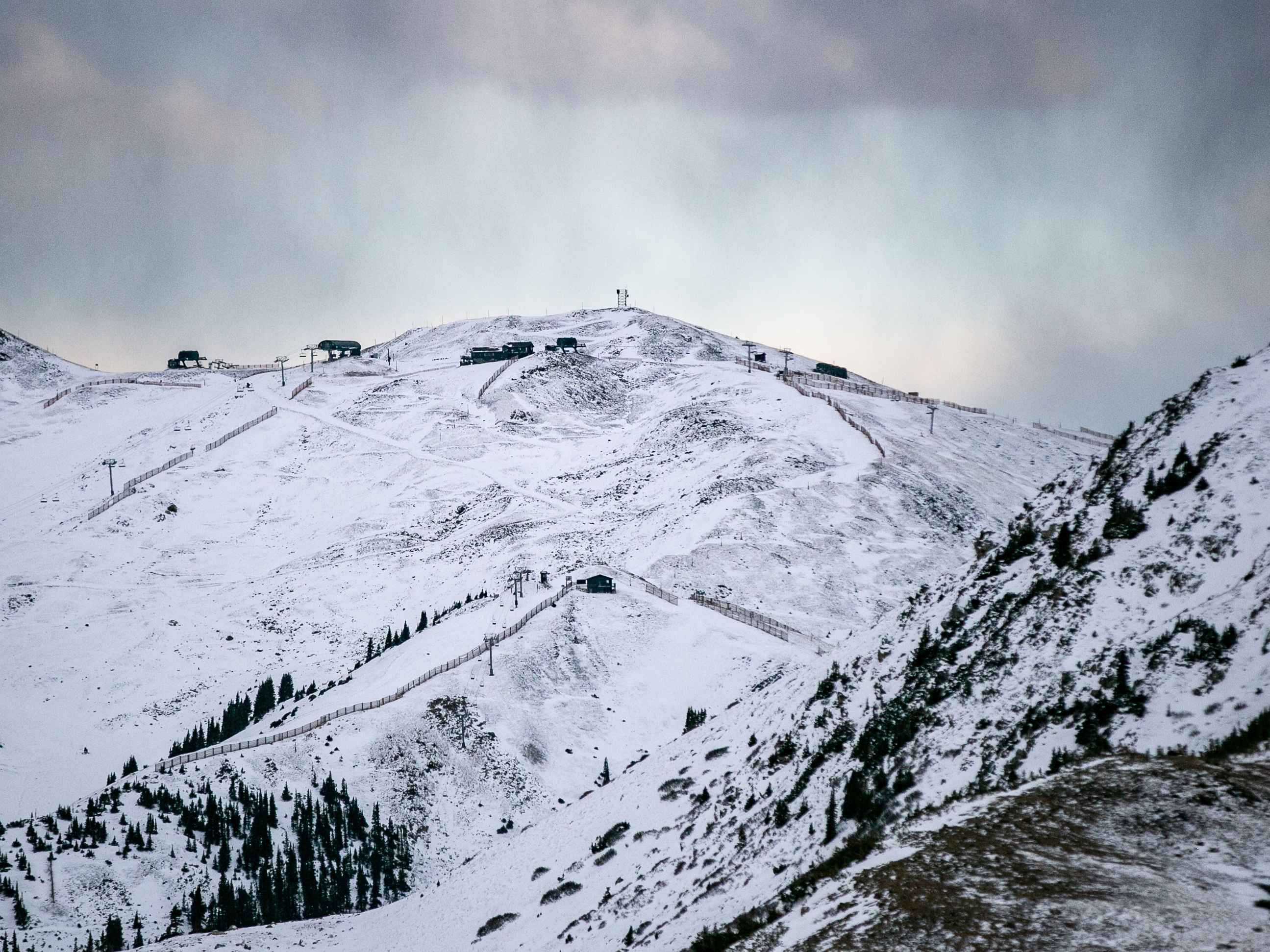 caption: Early season snow has started to accumulate at Colorado's Arapahoe Basin ski area, as seen from nearby Loveland Pass on Thanksgiving weekend.