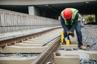 caption: Crews install concrete ties for light rail across Mercer Island in December 2016. The line will link Bellevue with Seattle and provide a light rail option between the two major cities. 
