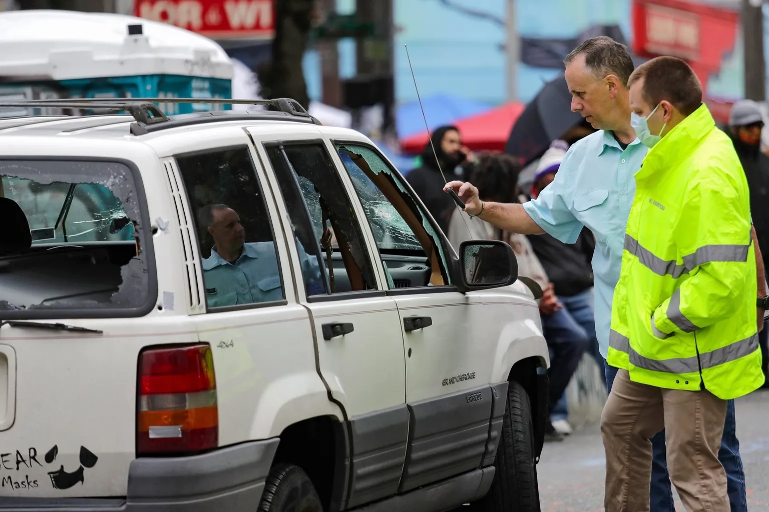 caption: Seattle police investigators look over the white Jeep that Robert West and Antonio Mays Jr. were in when they were shot in the Capitol Hill Occupied Protest zone. 